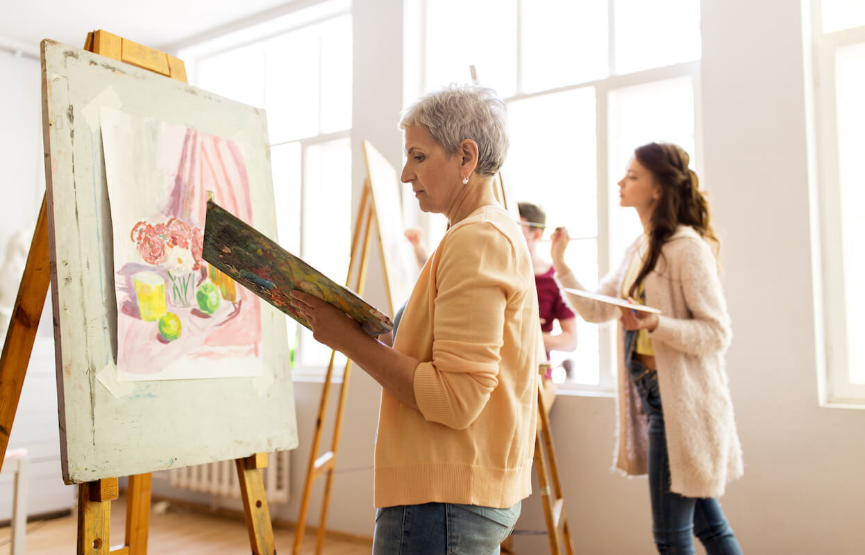 Woman Artist With Easel Painting At Art School