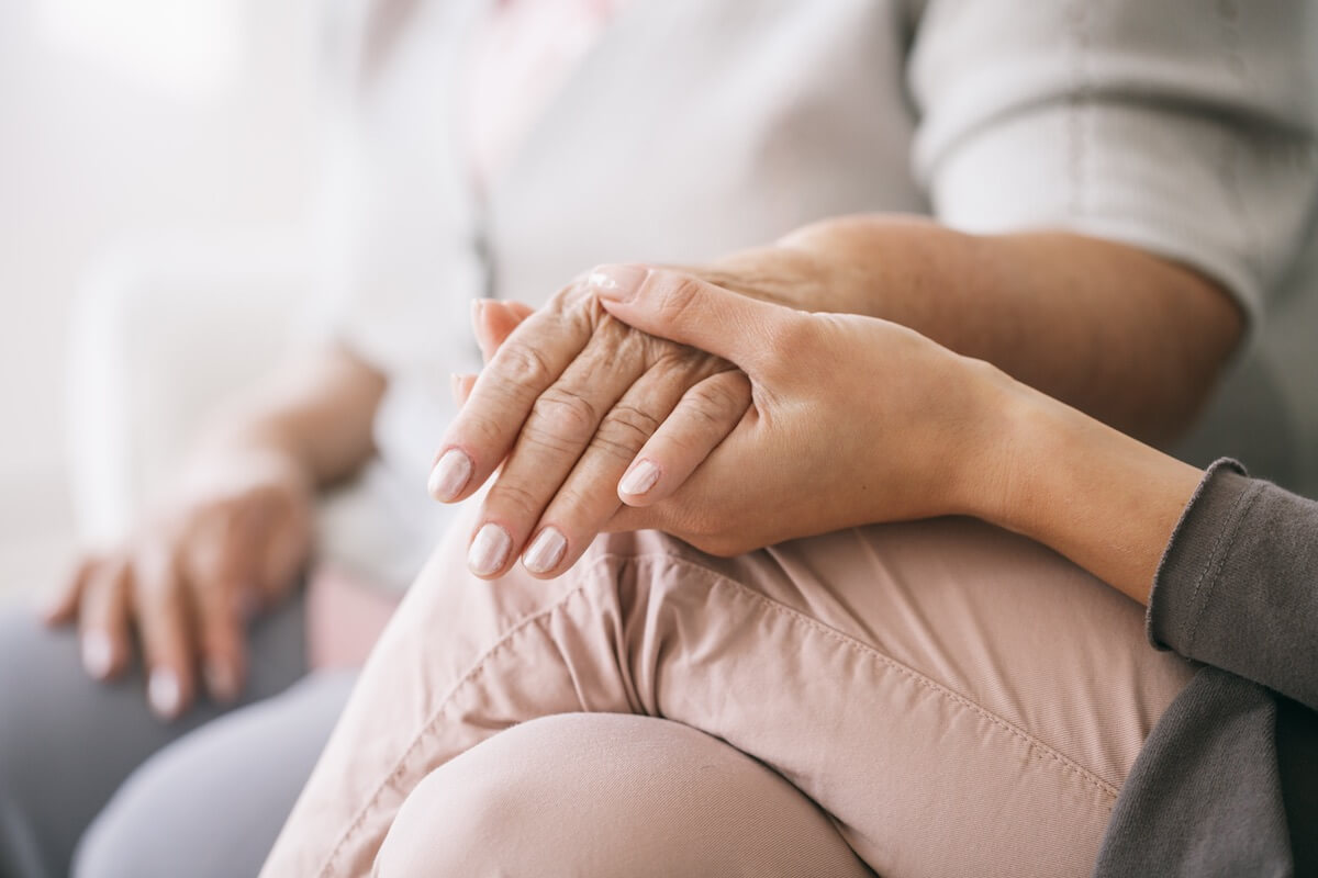 Close Up Of Caregiver Holding Woman's Hand