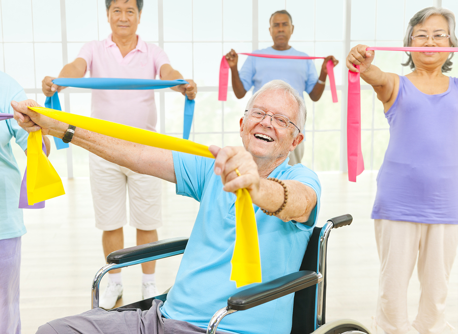 Mature Adults And A Disabled Person Exercising In A Gym